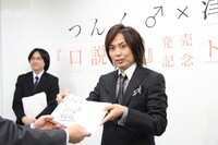 サインを入れた著書をファンに手渡すつんく♂。