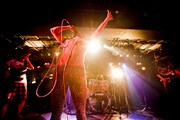 撃鉄のライブ写真。中央の豹柄レギンスを履いた半裸の男がボーカルの天野ジョージ。