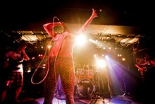 撃鉄のライブ写真。中央の豹柄レギンスを履いた半裸の男がボーカルの天野ジョージ。