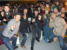 ザーサイを手にファンと記念撮影をする怒髪天。