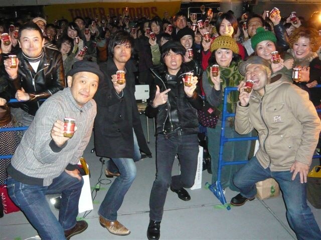 ザーサイを手にファンと記念撮影をする怒髪天。