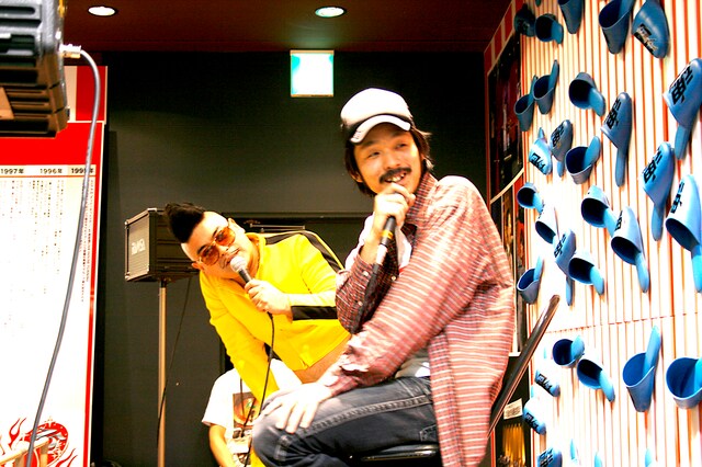 ステージ横に掲示されたバイト君の写真を見ながら「これは彼の遺影になりますね」と冗談まじりに語る暴動。