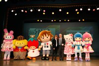 写真左よりマイメロディ、ポムポムプリン、いちごの王さま、タボくん、西川、佐藤社長、ハローキティ、キキ＆ララ。