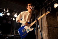 黒いパンツに白いワイシャツ、そしてサングラスというファッションで登場したmono（撮影：森リョータ）。