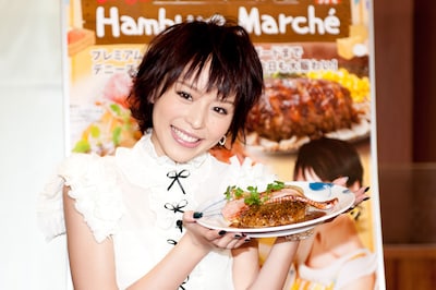 平野綾が手にしているのは「ハンバーグ マルシェ」イチ押しメニュー「厚切りベーコンステーキ＆ビーフ100%ハンバーグ」。