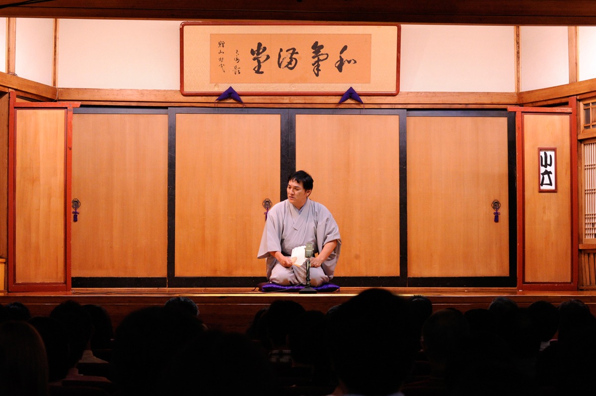 映画「落語物語」のワンシーン。高座に上がる小六。なお、寄席のシーンは東京に残る4軒の寄席（上野鈴本演芸場、新宿末廣亭、浅草演芸ホール、池袋演芸場）の全面バックアップによって、楽屋も含めすべて寄席での撮影が実現した。（C）2011「落語物語」製作委員会