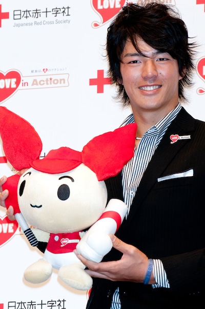 けんけつちゃんのぬいぐるみを手にした石川遼選手。