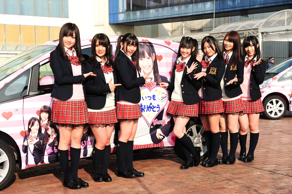 渡辺麻友仕様のエコデコカーを前に記念撮影をする渡り廊下走り隊7。写真左から小森美果、平嶋夏海、多田愛佳、渡辺麻友、仲川遥香、菊地あやか、岩佐美咲。