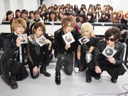 顔写真がプリントされたピクチャーレーベルCDを手にするメンバーたち。