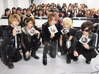 顔写真がプリントされたピクチャーレーベルCDを手にするメンバーたち。