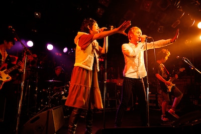 「愛が止まらない-Turn It Into Love-」を歌う鴇崎智史（写真右）と鈴木早智子（写真左）。