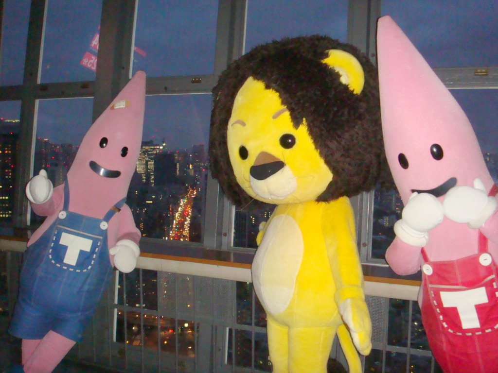 夜景をバックに記念撮影するノッポン兄（写真左）、ラグベベちゃん（写真中央）、ノッポン弟（写真右）。