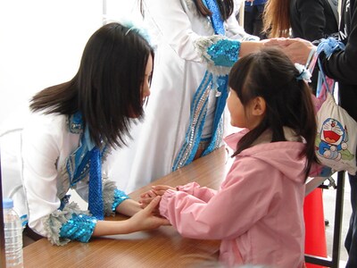 大阪握手会で、小さな女の子と握手する松井珠理奈（写真左）。 (C)PYTHAGORAS PROMOTION