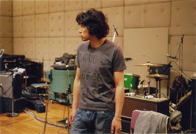 「LOVE & PEACE & CATS」Tシャツを身に着けた斉藤和義。