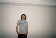 「LOVE & PEACE & BLUES」Tシャツを身に着けた吉井和哉。