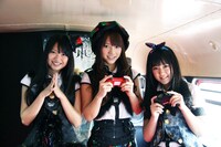 ロンドンバス車内でゲームを楽しむ3人。