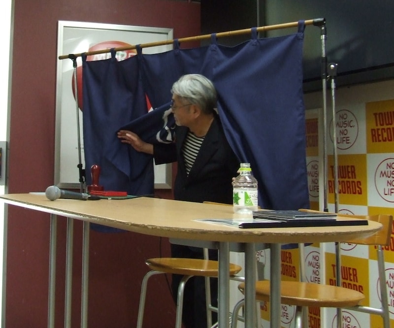 のれんをヒョイとくぐる細野晴臣。