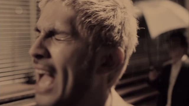 雨の中絶唱する平井堅（写真は「いとしき日々よ」ビデオクリップのワンシーン）。