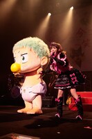 自分よりも大きな赤ちゃん（ベル坊）を連れて歌うしょこたん。