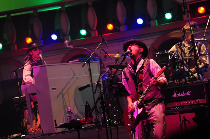 最新アーティスト写真と同じ衣装に身を包むユニコーン。写真左より阿部義晴（Key）、奥田民生、川西幸一（Dr）。（photo by TEPPEI）