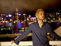 香港の美しい夜景をバックにたたずむ平井堅。