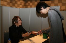 訪れたファンの用紙にスタンプを押す将（Vo）。