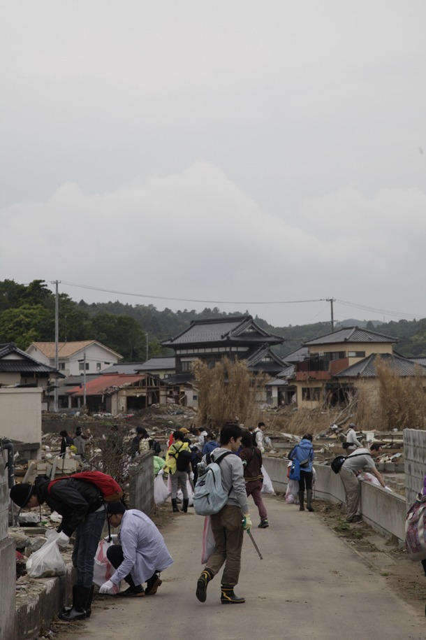 ツアー参加者による被災地のゴミ拾いの様子。（写真：新津保建秀）