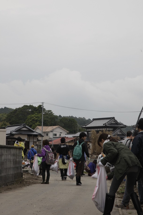 ツアー参加者による被災地のゴミ拾いの様子。（写真：新津保建秀）