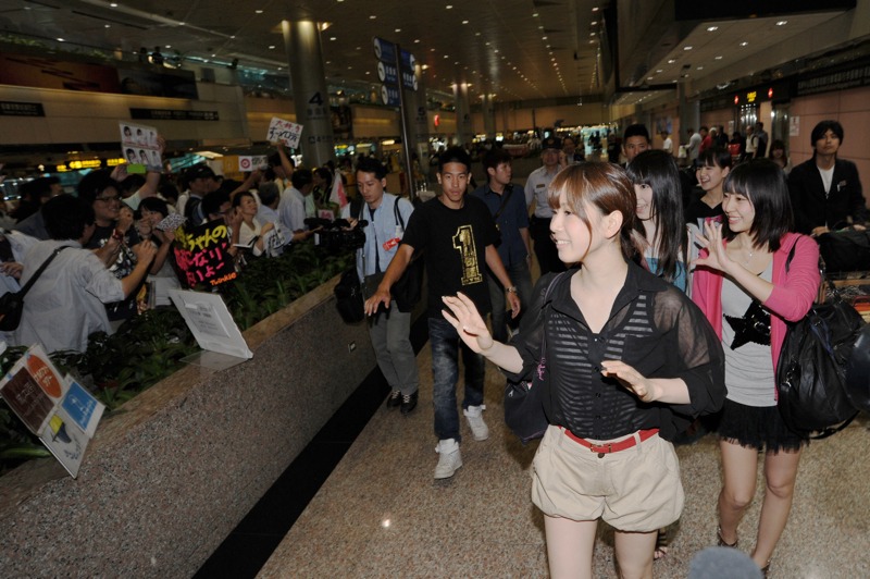 空港に到着したAKB48のメンバーを迎える熱狂的なファン。