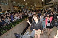 空港に到着したAKB48のメンバーを迎える熱狂的なファン。