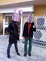 写真は京都アニメーションの前で感慨深げにポーズをとる2 ANIMEny DJ's。