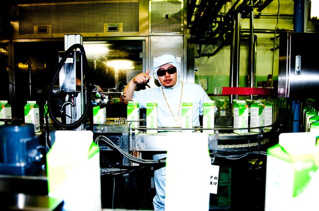 工場のベルトコンベアに囲まれて、まさに“物流”の最前線を見守るShibori。