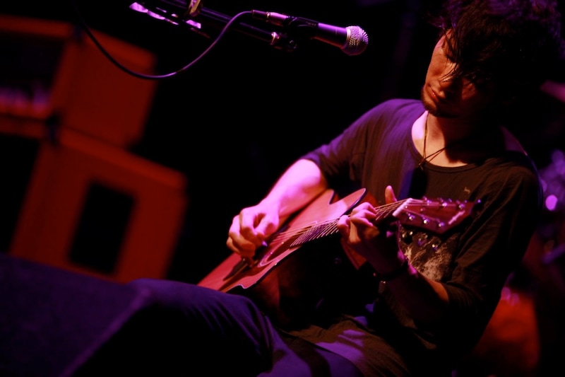 アコースティックスタイルでパフォーマンスを披露するTK(Vo, G)。