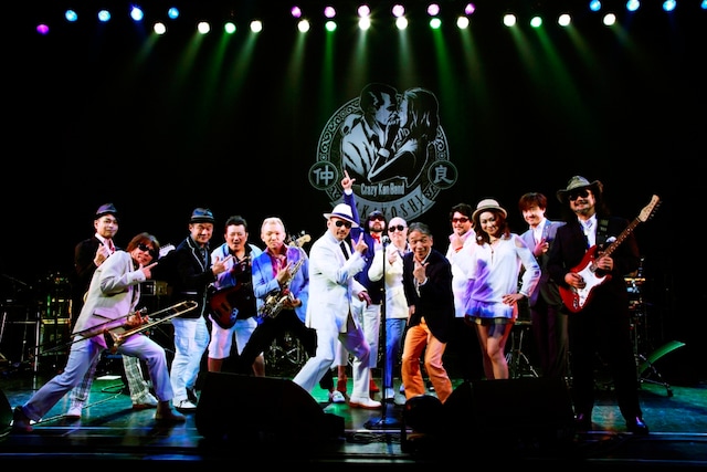 クレイジーケンバンドのメンバーと、「イイネ！」ポーズをキメるマチャアキ（写真右から5番目）。