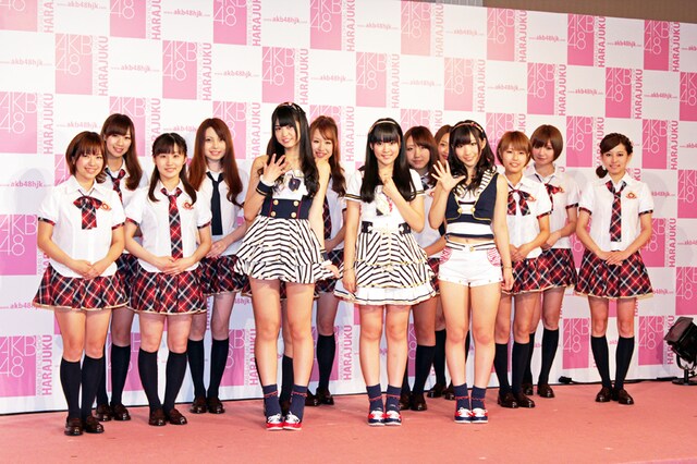 「AKB48 OFFICIAL SHOP HARAJUKU」店員と記念撮影するAKB48メンバー。ショップ店員のユニフォームは、AKB48の衣装を手掛ける茅野しのぶのデザインによるもの。