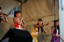 イベントタイトルの由来は、イベント広場の急傾斜から。その急傾斜具合を体で表現し「（アキレス腱）伸びてるかーい！」という珍しいフレーズで観客を煽った玉井詩織（写真中央）。