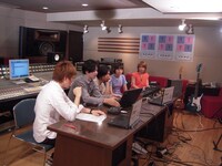 写真は「生ラマ」配信中のスタジオの様子。コメントが表示されるPCを観るLAMAの4人。