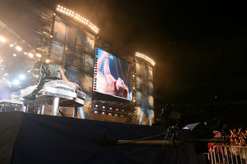 クリスタルピアノの上でマイクを握りしめるYOSHIKI。