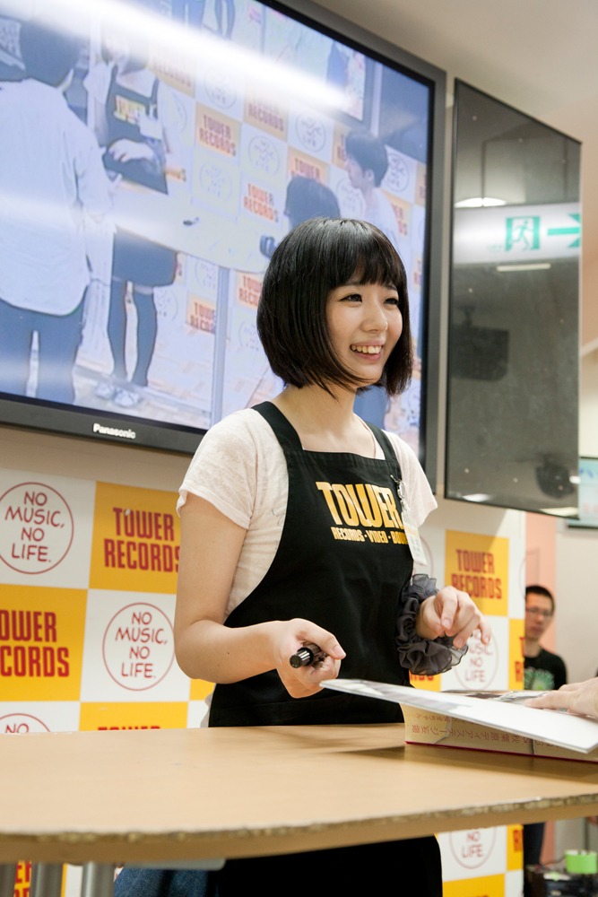 「FREECELL特別号 アキバ妄撮」にサインをする夢眠ねむ。