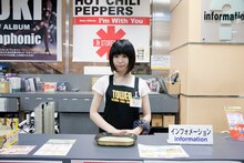 タワレコ店員のユニフォームとネームプレートを身に付けた夢眠ねむ。