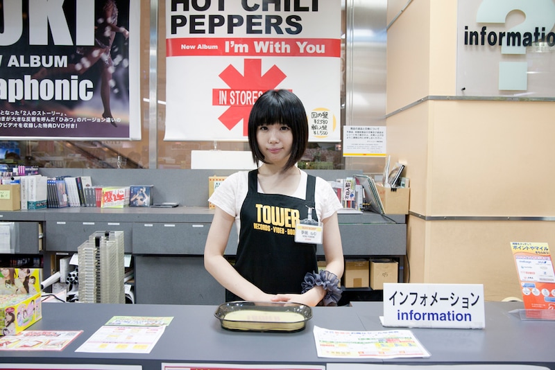 タワレコ店員のユニフォームとネームプレートを身に付けた夢眠ねむ。