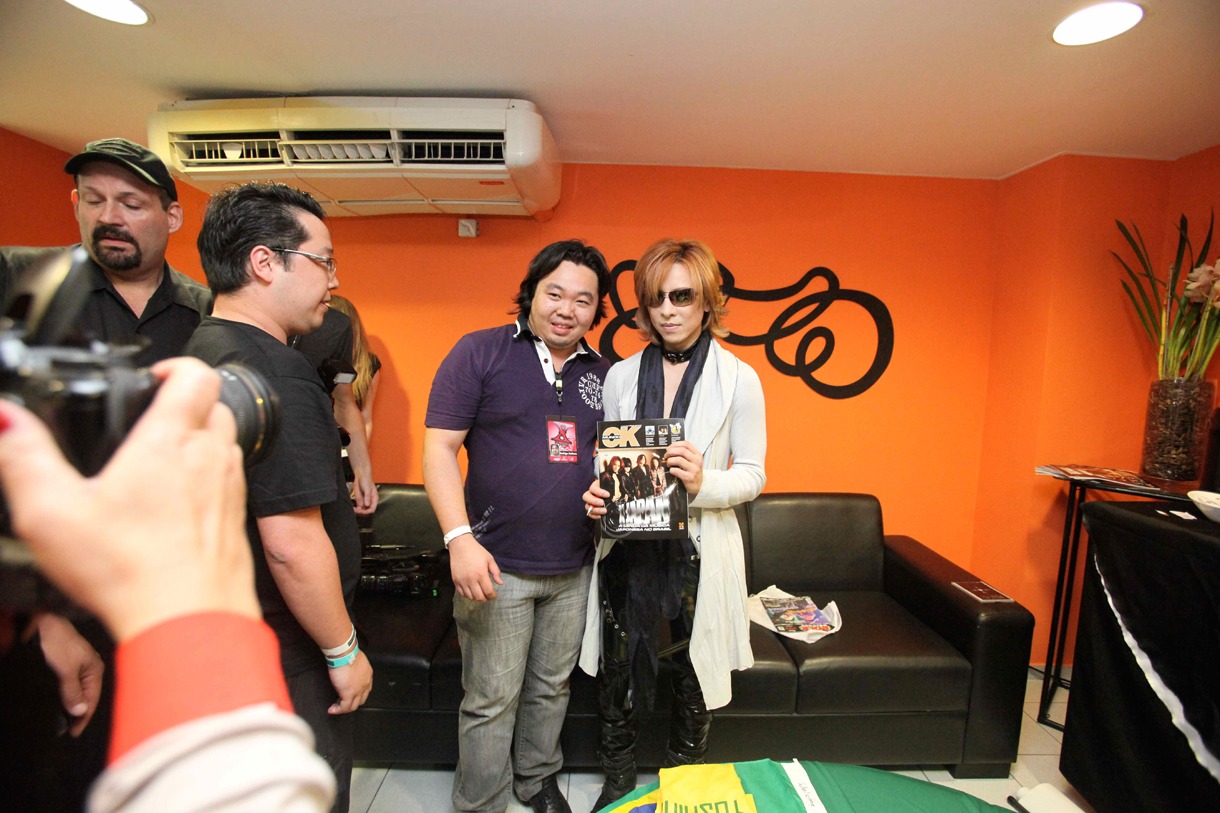 X JAPANが表紙を飾った現地雑誌を手に持ち記念撮影に応じるYOSHIKI（写真右）。