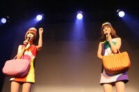 バックの中からオリジナルのチロルチョコを取り出し、棟上げ式のようにばらまくレナ＆リサ。