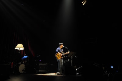 ライブ中盤の弾き語りコーナーの様子。広いステージにひとりで立ち歌う星野源。