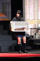 副賞のアルゼンチンレッドテグーを抱え、微妙な表情を見せる小木曽汐莉。