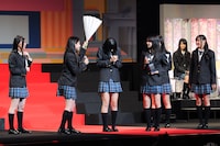 松本梨奈（写真左から2番目）にハリセンで「アイドルとして一線超えちゃダメでしょ！」と突っ込まれる金子栞（左から3番目）。