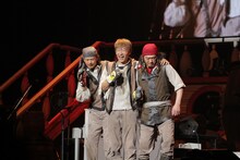 「メダカの格好」を歌うEBI、川西、テッシー。この曲では、3人の足がマジックテープで結ばれており、3人4脚のかたちで左右に移動するパフォーマンスが観られた。