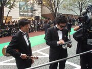 観客の声援に応えてサインをする前野健太（右）と、その代わりにギターを持つ松江哲明。