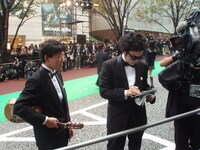 観客の声援に応えてサインをする前野健太（右）と、その代わりにギターを持つ松江哲明。