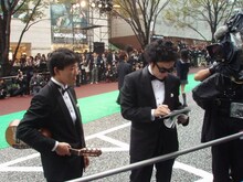 観客の声援に応えてサインをする前野健太（右）と、その代わりにギターを持つ松江哲明。